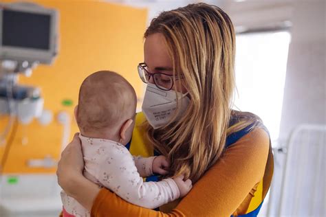 Csecsemő, aki sír és egy anya, aki próbálja megnyugtatni