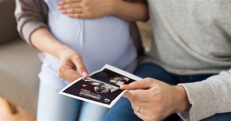 Orvos konzultál a szülőkkel a baba fejlődéséről