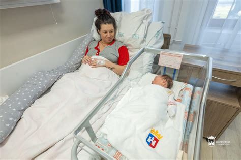 Szülő fürdeti újszülöttjét babakádban
