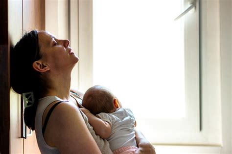 Aggódó anya néz egy alvó csecsemőre