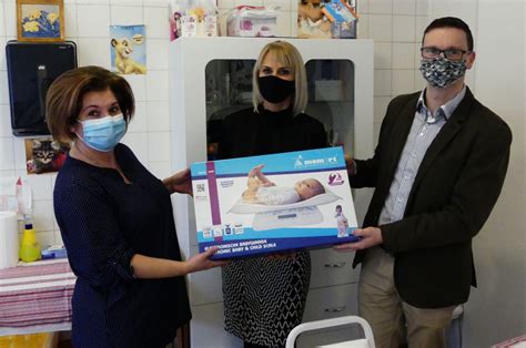 Szülők orvossal beszélgetnek egy újszülöttről, háttérben orvosi eszközökkel