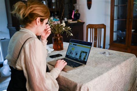 Kismama laptop előtt, babával a kezében, utalva a GYED/GYES melletti munkavégzésre