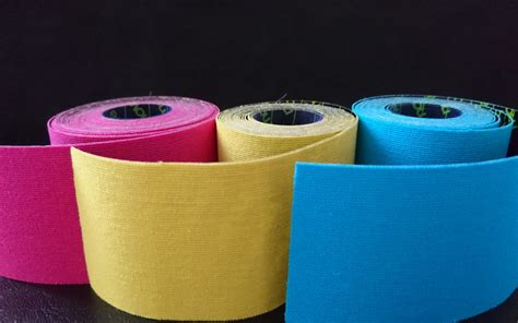 Terhes kismama pocakján színes kinesio-tape szalagok