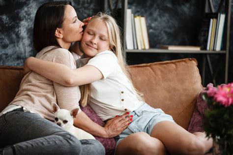 Anya és gyermek nevetve ölelkeznek egy kanapén
