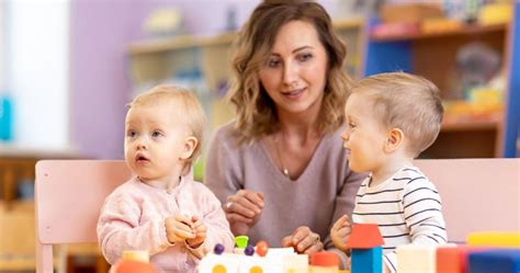 Kisgyermekekkel játszó bölcsődei nevelő