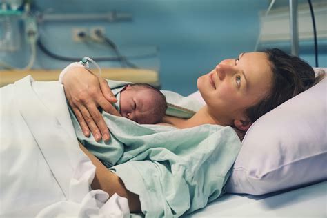 Pár a szülőszobában, az édesapa támogatja a vajúdó édesanyát