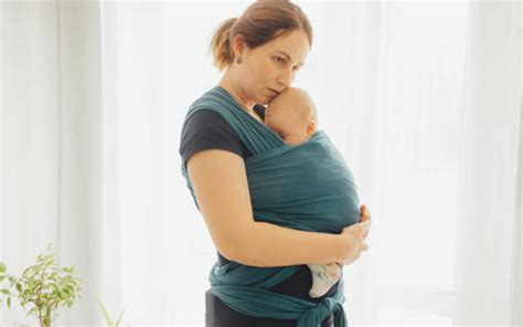 Anya és baba hordozókendőben, sétálva