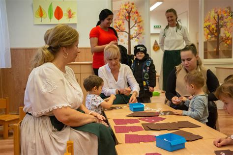 Kisgyermeknevelők beszélgetnek szülőkkel a bölcsődében