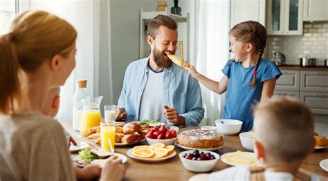 Család együtt vacsorázik az asztal körül, nevetnek