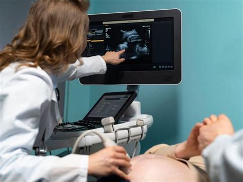 Nőgyógyász egy monitor előtt, amely a petefészek ultrahang képét mutatja, tüszőstimuláció közben