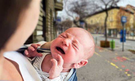 Nő térdeplő pozícióban, kezében babával