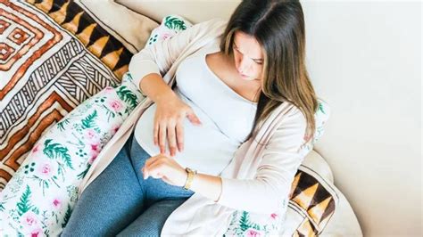 Terhes nő, aki a gyomrát fogja a fájdalomtól