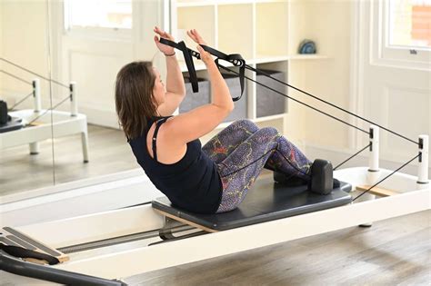 Nő reformer pilates gyakorlatot végez