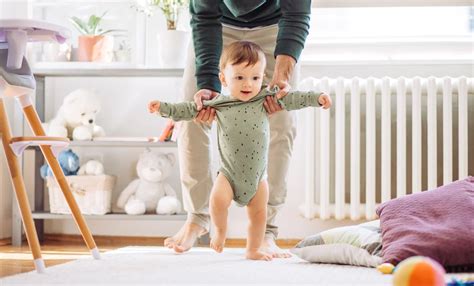 Szülő bátorítja gyermekét az első lépések megtételében