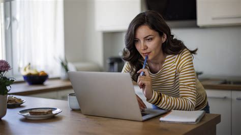 Kismama otthoni környezetben, laptop előtt dolgozik
