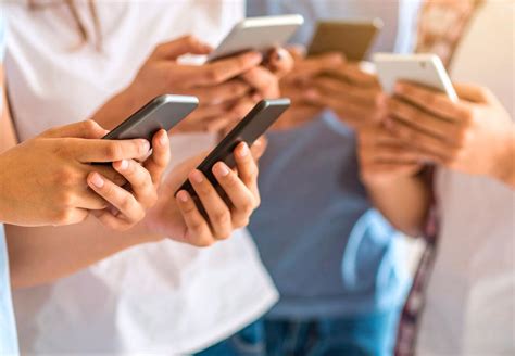 Tinédzserek mobiltelefonokkal, szociális médiát böngésznek