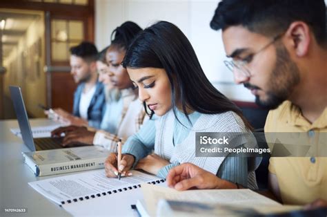 Egyetemista diákok tanulnak a campuson, háttérben egyetemi épületek