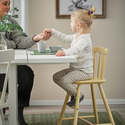 Gyermek ülésmagasítóban egy felnőtt széken