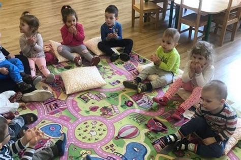 Bölcsődés gyerekek játék közben, gondozók felügyeletével