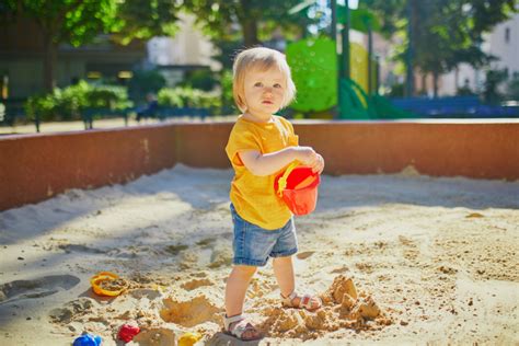 Homokozóban játszó baba
