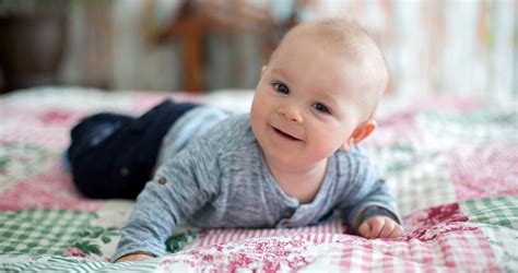 három hónapos baba hason fekve emeli a fejét