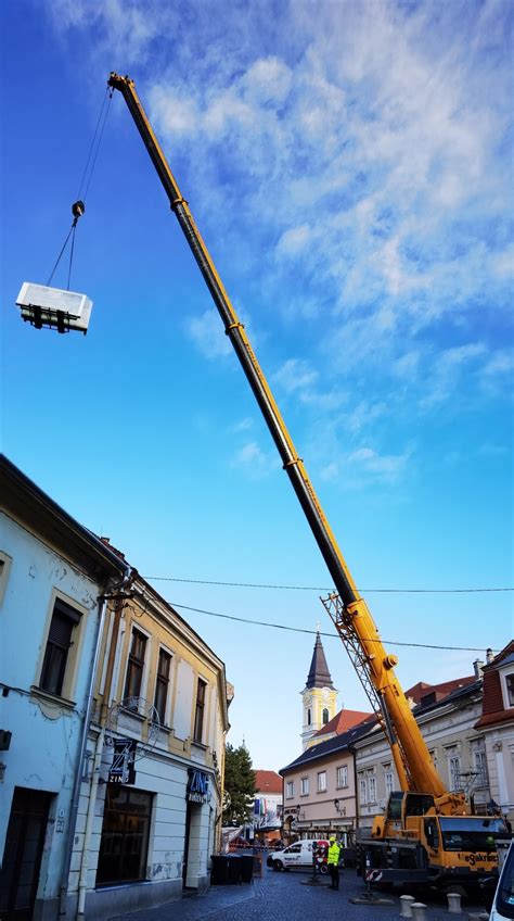 Daruval végzett emelési művelet. A kép illusztrálja a teher emelését és mozgatását építkezési környezetben.