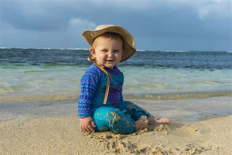 Baba naptejjel és sapkával a strandon
