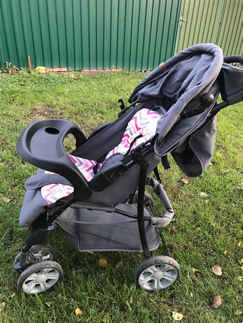 Kisbaba pelenkázó táskával a babakocsi mellett