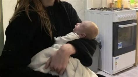 Egy nyugodt, otthoni környezetben szülő nő képe, babájával a karjában