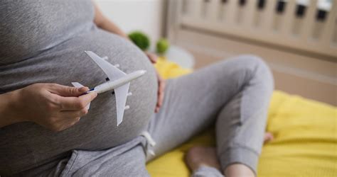 Terhes nő utazik repülőn, a háttérben orvosi papírok