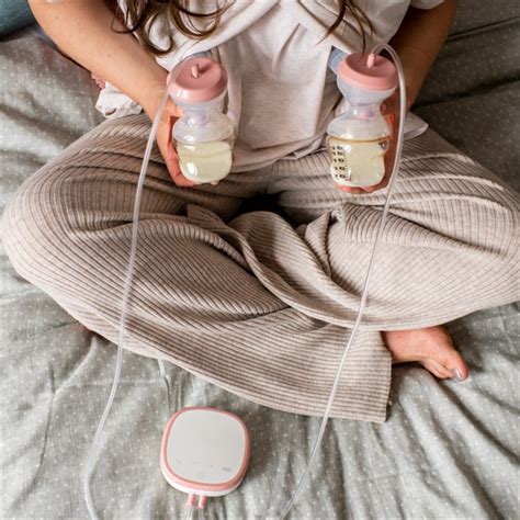 Nő, aki Tommee Tippee elektromos mellszívót használ diszkréten, miközben más tevékenységet végez