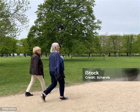 Idős pár kézenfogva sétál a parkban
