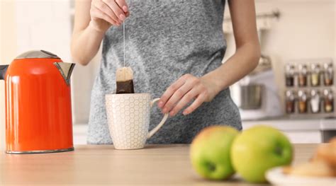kismama, aki éppen egy csésze forró teát iszik, miközben pihen