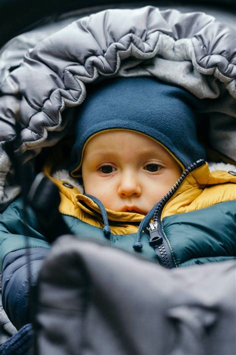Babakocsiban alvó, meleg bundazsákban lévő csecsemő