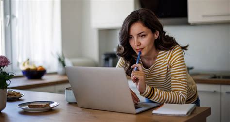 Nő laptop előtt dolgozik otthon kisgyermekkel
