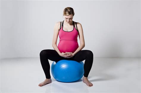 Terhes nő fit ball labdán végez medencekörzést