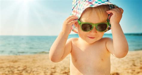 Baba napozás közben sapkában és napszemüvegben