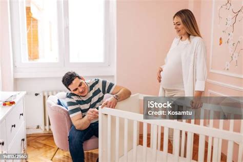 Terhes nő pihen egy kanapén, miközben a hasát simogatja