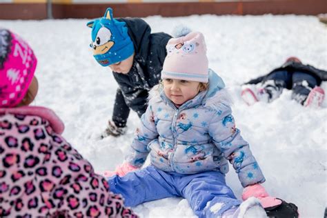 Gyerekek overallban játszanak a hóban