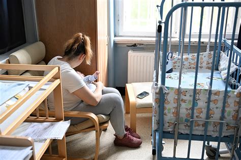 Egy szülés utáni depresszióval küzdő anya illusztrációja, aki szomorúan ül a babája mellett