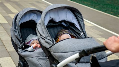 két gyermekkel közlekedő szülők iker babakocsival