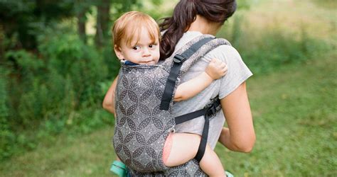 Anya háton hordozza nagyobb gyermekét ergonomikus hordozóban