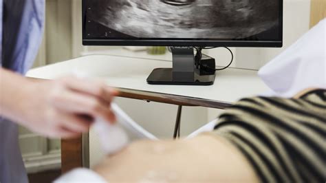 Terhes nő magzati szívhang monitorral a hasán