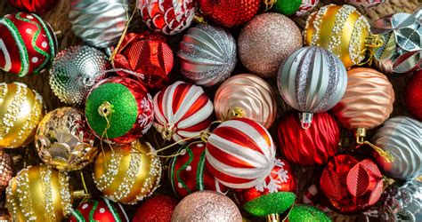 Gyermekek, akik karácsonyi gömbdíszeket festenek, tenyérlenyomatokkal díszítve.