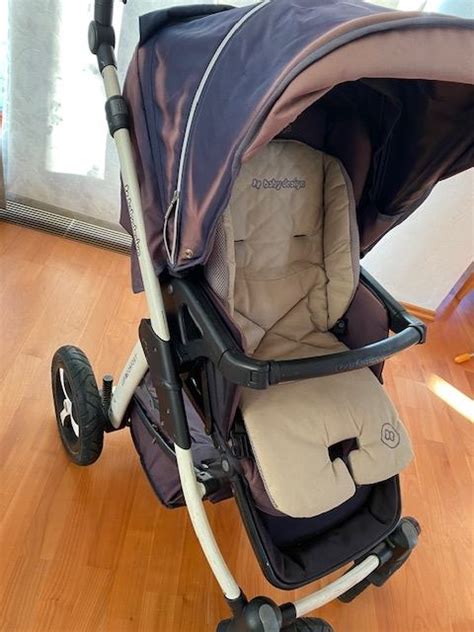 Gyermek ül a Baby Design Lupo Comfort sportrészében, vidáman néz ki