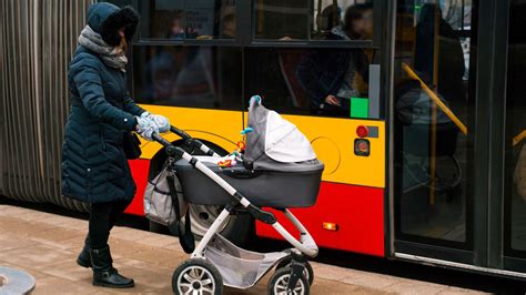 Nő bankjegyautomatánál babakocsival