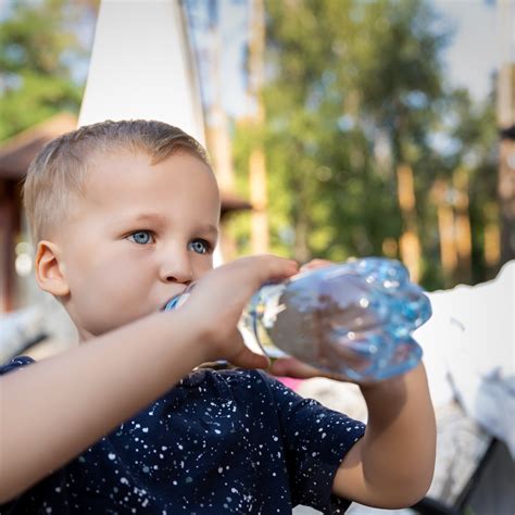 Mosolygó kisgyermekek játék közben, egy nevelővel a háttérben