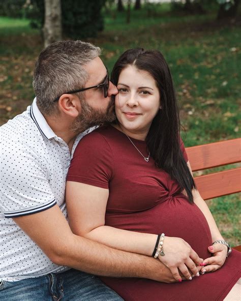 Kismama masszírozza a babáját, bemutatva a helyes technikát