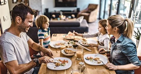 Család közös reggelinél, mosolyogva.
